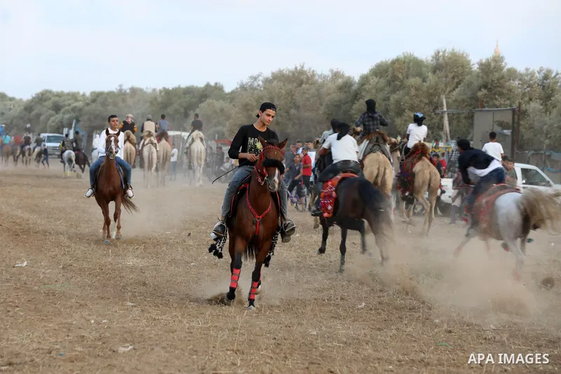 Palestinians ride horses and camels during a local race, in Nuseirat, in the center of Gaza strip on October 8, 2021. Breeders of Arabian horses in Gaza have been struggling to secure the necessary medicines and vaccinat...