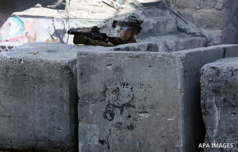Members of Israeli troops take position during clashes with Palestinian protesters in the West Bank city of Hebron, on October 8, 2021. Photo by Mamoun Wazwaz