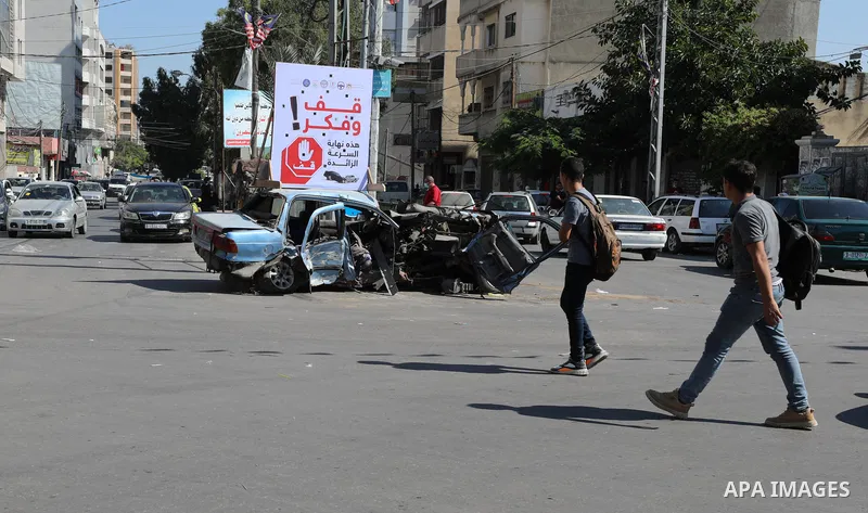 Palestinians walk near the cars destroyed by accidents, in Gaza City on October 011 2021. Dealing with traffic accident cases and their repercussions does not fall under the Traffic Law only, but also under the Penal Cod...