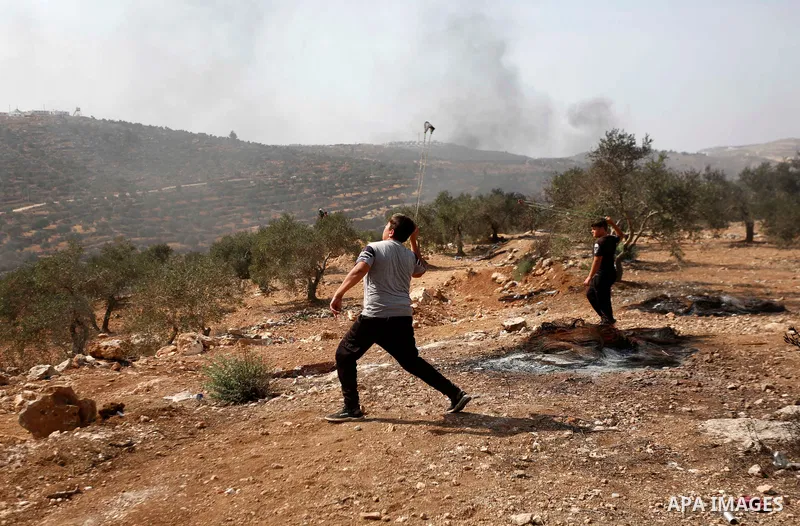 Palestinian protesters clash with Israeli troops during a demonstration against settlements in the village of Beita, near the West Bank city of Nablus on October 15, 2021. Photo by WAFA