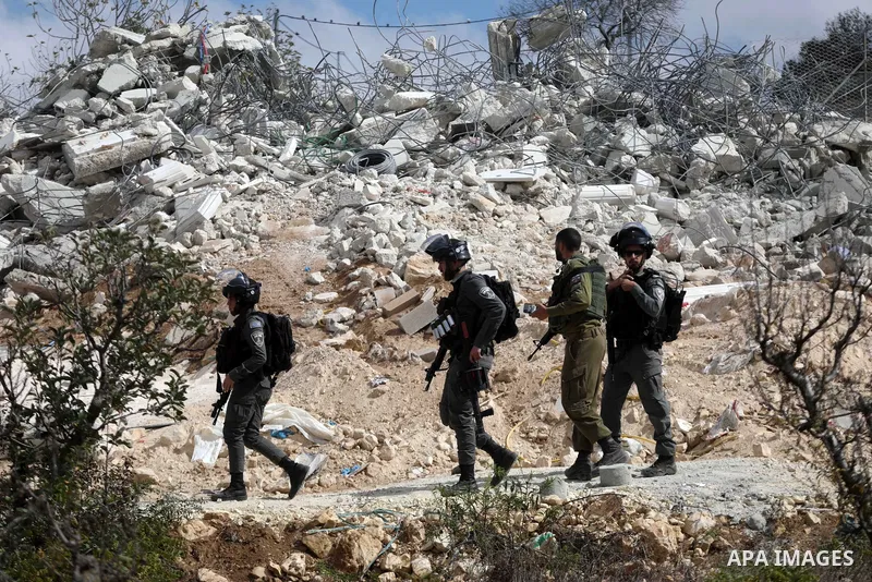 Israeli forces stand guard during an Israeli bulldozer demolished a Palestinian house located within the "Area C" of the West Bank, where Israel retains full control over planning and construction, under the pretext of b...