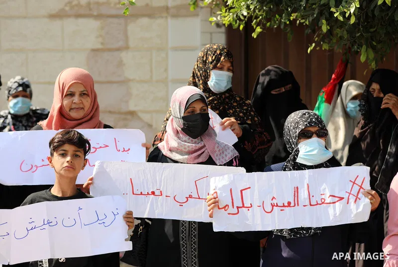 Palestinians of Social Affairs take part in a protest to demand the payment of their allowances, in front of the Ministry of Social Development office in Gaza on October 21, 2021. Photo by Ramadan El-agha