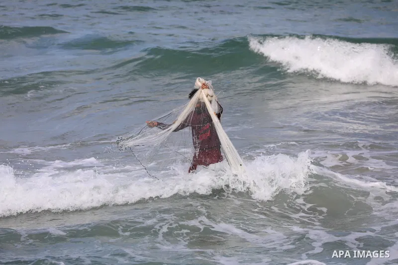 A Palestinian fisherman collects fish nets on the beach of the Mediterranean sea in Gaza City, on October 23, 2021. Fishing is a major source of revenue for the impoverished Palestinian enclave. Israel, which maintains a...