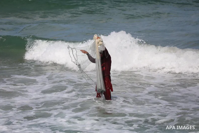 A Palestinian fisherman collects fish nets on the beach of the Mediterranean sea in Gaza City, on October 23, 2021. Fishing is a major source of revenue for the impoverished Palestinian enclave. Israel, which maintains a...