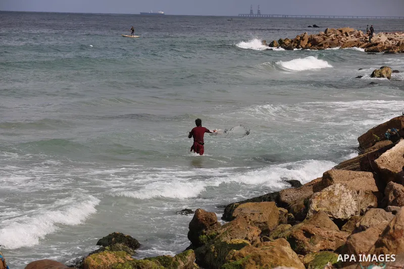 A Palestinian fisherman collects fish nets on the beach of the Mediterranean sea in Gaza City, on October 23, 2021. Fishing is a major source of revenue for the impoverished Palestinian enclave. Israel, which maintains a...