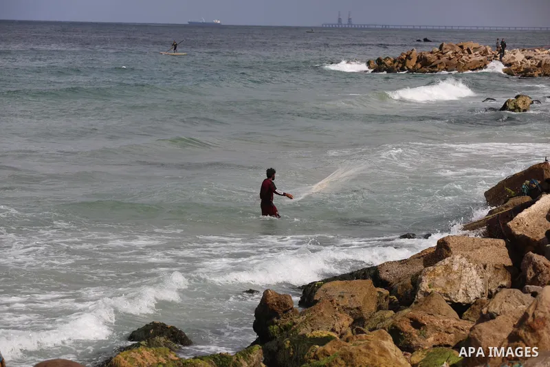 A Palestinian fisherman collects fish nets on the beach of the Mediterranean sea in Gaza City, on October 23, 2021. Fishing is a major source of revenue for the impoverished Palestinian enclave. Israel, which maintains a...