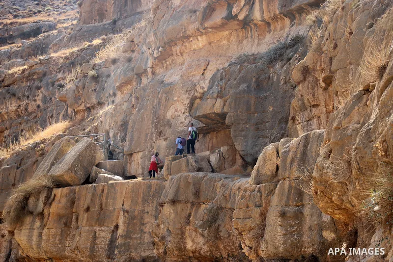 Palestinian adventurers walk amid dangerous cliffs during their journey to explore Valley and Cave of Saint Khreitoun near the West Bank city of Bethlehem, on October 25, 2021. To the southeast of Bethlehem, between the...