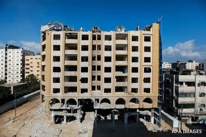 Palestinian workers remove the rubbles of al-Jawhara tower which was hit by Israeli strikes during the recent 11-day conflict between Israel and Hamas on May, in Gaza city on October 23, 2021. The tower was bombed with m...