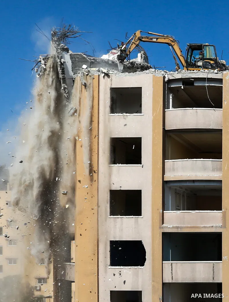Palestinian workers remove the rubbles of al-Jawhara tower which was hit by Israeli strikes during the recent 11-day conflict between Israel and Hamas on May, in Gaza city on October 23, 2021. The tower was bombed with m...