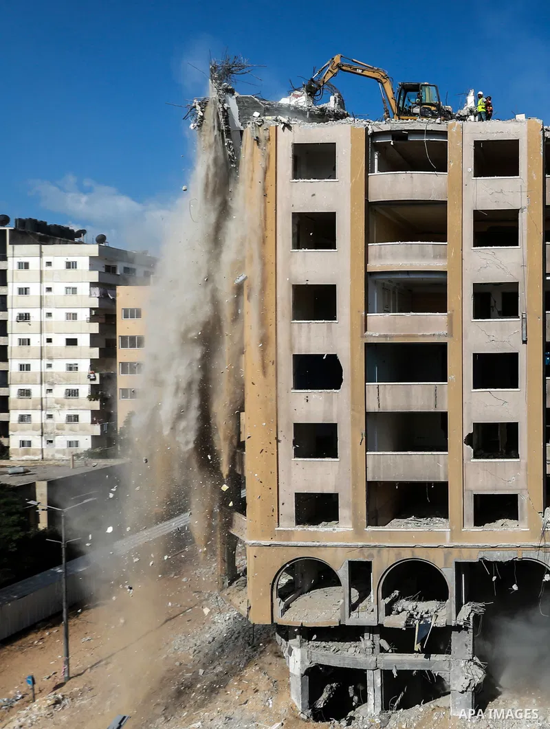 Palestinian workers remove the rubbles of al-Jawhara tower which was hit by Israeli strikes during the recent 11-day conflict between Israel and Hamas on May, in Gaza city on October 23, 2021. The tower was bombed with m...