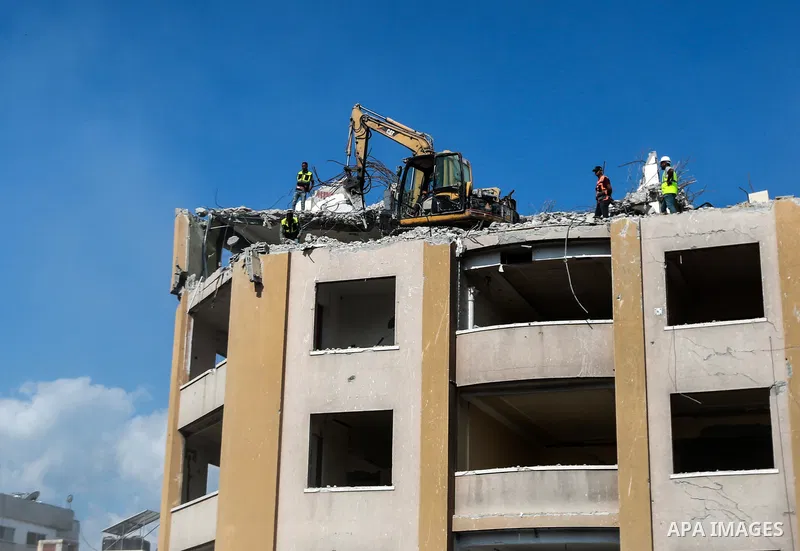 Palestinian workers remove the rubbles of al-Jawhara tower which was hit by Israeli strikes during the recent 11-day conflict between Israel and Hamas on May, in Gaza city on October 23, 2021. The tower was bombed with m...