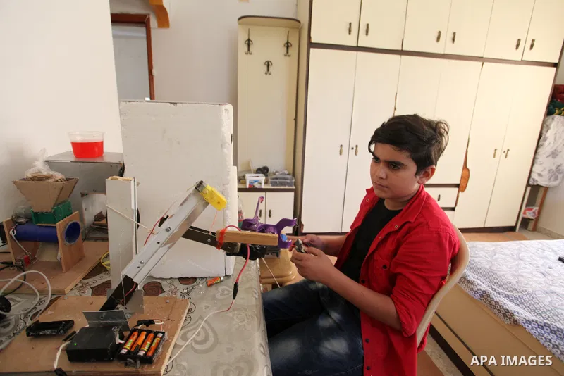 Palestinian inventor Mohammad Al-Hallaq,13, displays his small inventions at his home in Khan Yunis, in the southern Gaza Strip, on October 23, 2021. Al-Hallaq invented the robot for special needs and portable refrigerat...