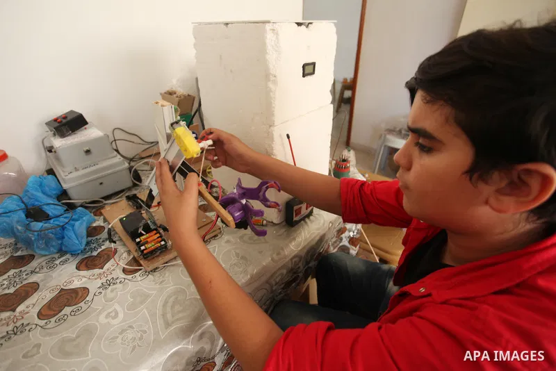 Palestinian inventor Mohammad Al-Hallaq,13, displays his small inventions at his home in Khan Yunis, in the southern Gaza Strip, on October 23, 2021. Al-Hallaq invented the robot for special needs and portable refrigerat...