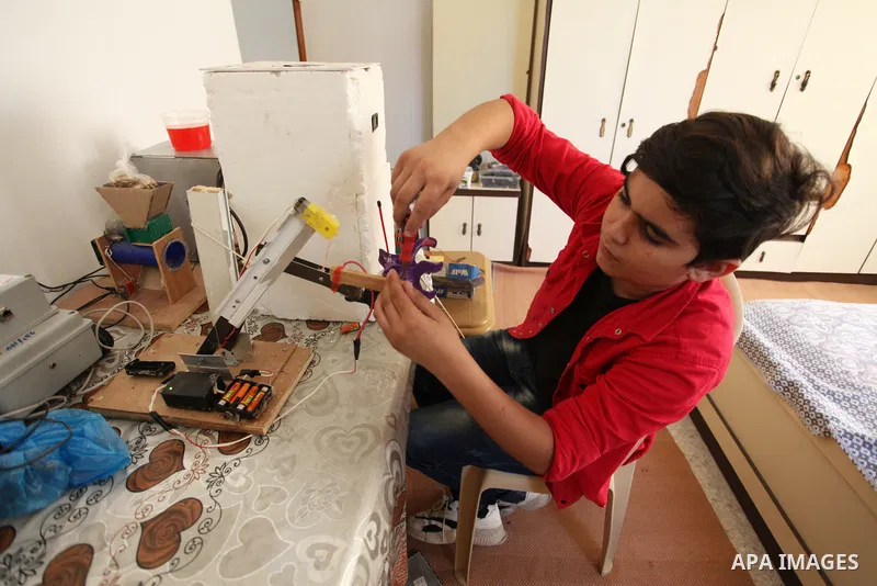 Palestinian inventor Mohammad Al-Hallaq,13, displays his small inventions at his home in Khan Yunis, in the southern Gaza Strip, on October 23, 2021. Al-Hallaq invented the robot for special needs and portable refrigerat...