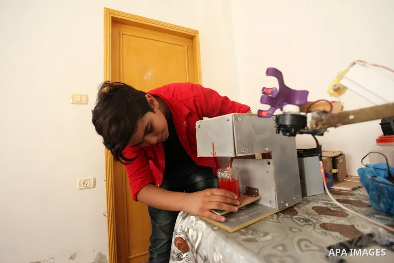 Palestinian inventor Mohammad Al-Hallaq,13, displays his small inventions at his home in Khan Yunis, in the southern Gaza Strip, on October 23, 2021. Al-Hallaq invented the robot for special needs and portable refrigerat...
