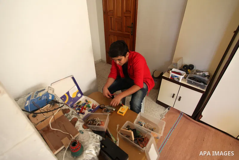 Palestinian inventor Mohammad Al-Hallaq,13, displays his small inventions at his home in Khan Yunis, in the southern Gaza Strip, on October 23, 2021. Al-Hallaq invented the robot for special needs and portable refrigerat...