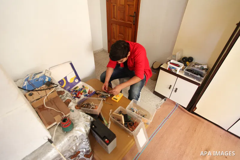 Palestinian inventor Mohammad Al-Hallaq,13, displays his small inventions at his home in Khan Yunis, in the southern Gaza Strip, on October 23, 2021. Al-Hallaq invented the robot for special needs and portable refrigerat...