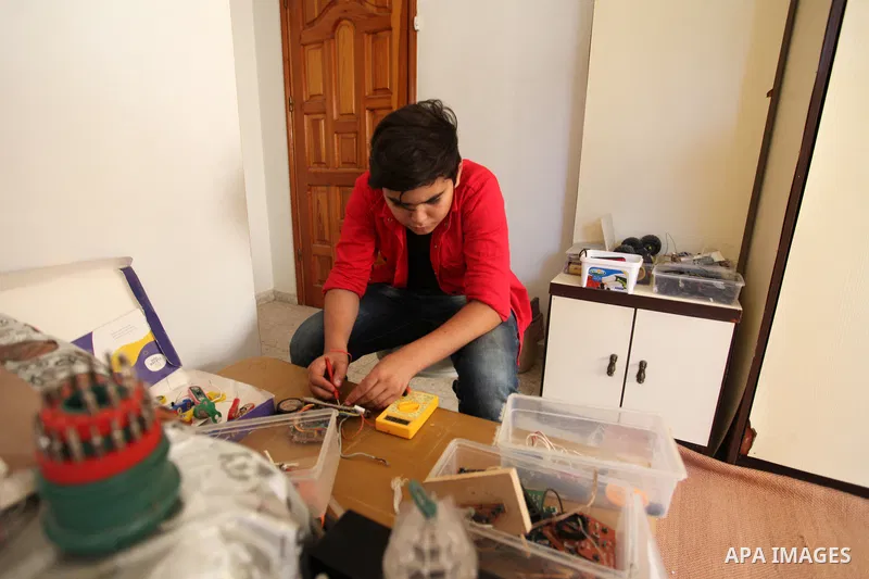 Palestinian inventor Mohammad Al-Hallaq,13, displays his small inventions at his home in Khan Yunis, in the southern Gaza Strip, on October 23, 2021. Al-Hallaq invented the robot for special needs and portable refrigerat...
