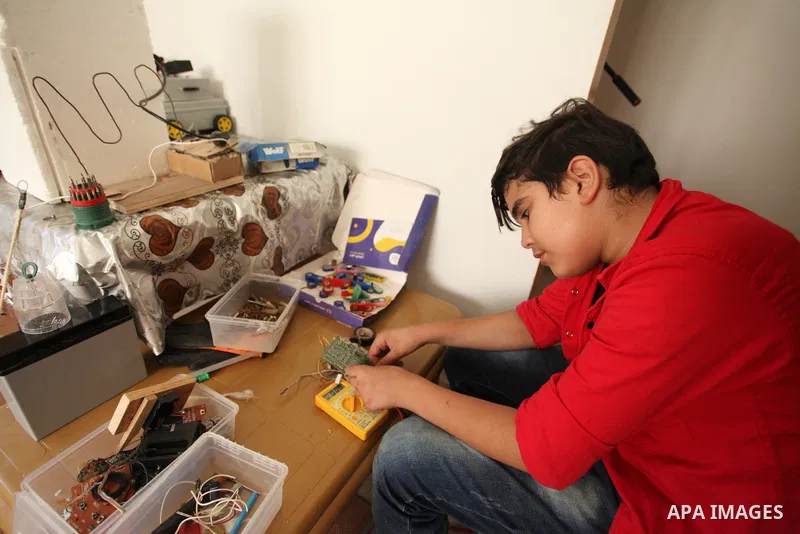 Palestinian inventor Mohammad Al-Hallaq,13, displays his small inventions at his home in Khan Yunis, in the southern Gaza Strip, on October 23, 2021. Al-Hallaq invented the robot for special needs and portable refrigerat...