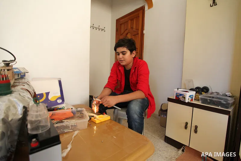 Palestinian inventor Mohammad Al-Hallaq,13, displays his small inventions at his home in Khan Yunis, in the southern Gaza Strip, on October 23, 2021. Al-Hallaq invented the robot for special needs and portable refrigerat...