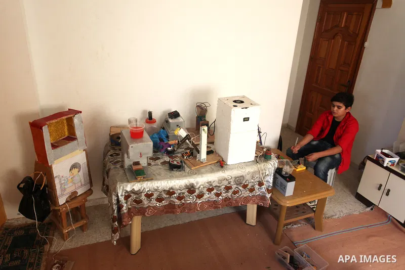 Palestinian inventor Mohammad Al-Hallaq,13, displays his small inventions at his home in Khan Yunis, in the southern Gaza Strip, on October 23, 2021. Al-Hallaq invented the robot for special needs and portable refrigerat...