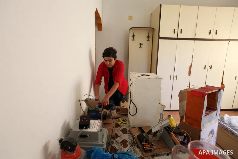 Palestinian inventor Mohammad Al-Hallaq,13, displays his small inventions at his home in Khan Yunis, in the southern Gaza Strip, on October 23, 2021. Al-Hallaq invented the robot for special needs and portable refrigerat...