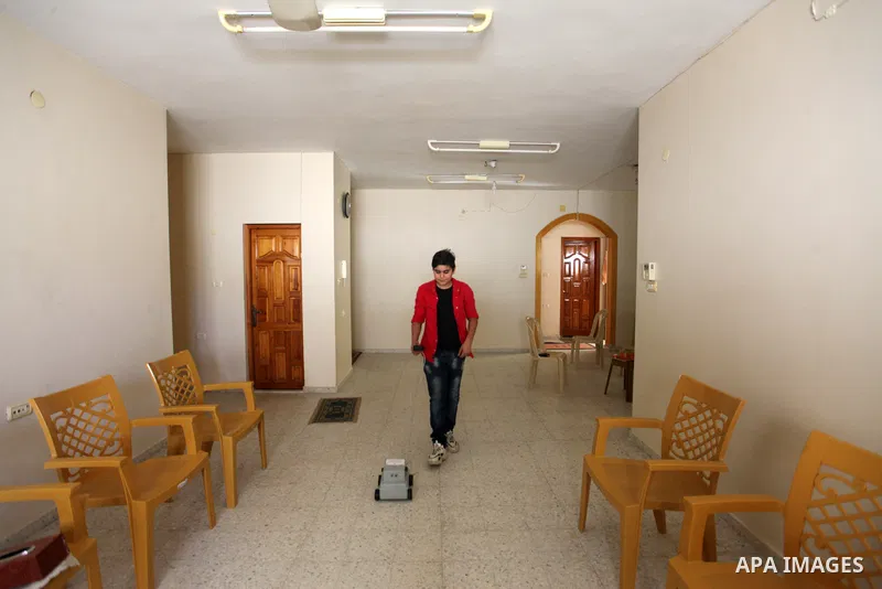 Palestinian inventor Mohammad Al-Hallaq,13, displays his small inventions at his home in Khan Yunis, in the southern Gaza Strip, on October 23, 2021. Al-Hallaq invented the robot for special needs and portable refrigerat...