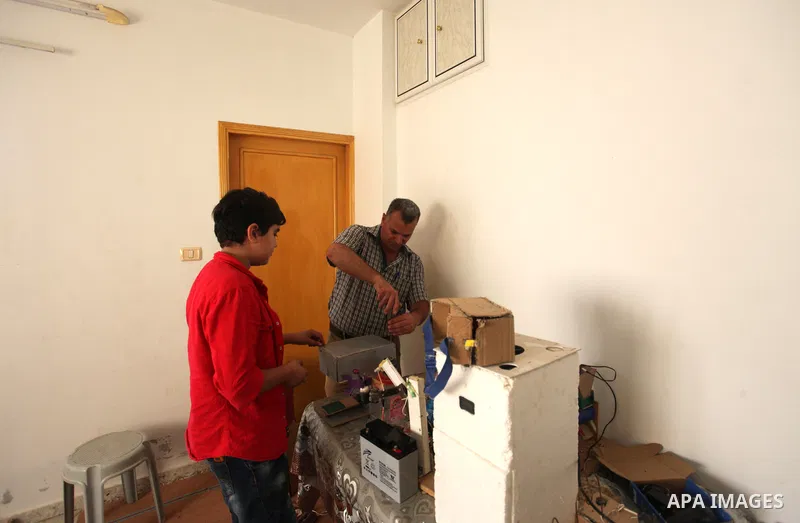 Palestinian inventor Mohammad Al-Hallaq,13, displays his small inventions at his home in Khan Yunis, in the southern Gaza Strip, on October 23, 2021. Al-Hallaq invented the robot for special needs and portable refrigerat...