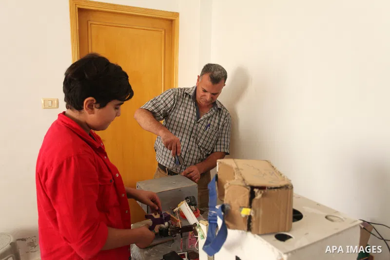 Palestinian inventor Mohammad Al-Hallaq,13, displays his small inventions at his home in Khan Yunis, in the southern Gaza Strip, on October 23, 2021. Al-Hallaq invented the robot for special needs and portable refrigerat...