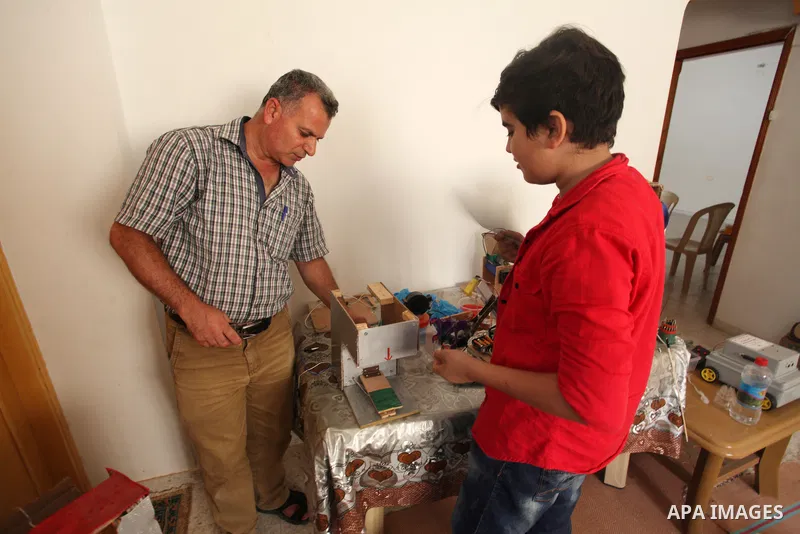 Palestinian inventor Mohammad Al-Hallaq,13, displays his small inventions at his home in Khan Yunis, in the southern Gaza Strip, on October 23, 2021. Al-Hallaq invented the robot for special needs and portable refrigerat...