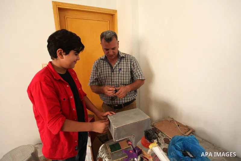 Palestinian inventor Mohammad Al-Hallaq,13, displays his small inventions at his home in Khan Yunis, in the southern Gaza Strip, on October 23, 2021. Al-Hallaq invented the robot for special needs and portable refrigerat...