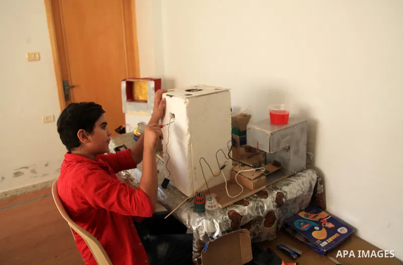 Palestinian inventor Mohammad Al-Hallaq,13, displays his small inventions at his home in Khan Yunis, in the southern Gaza Strip, on October 23, 2021. Al-Hallaq invented the robot for special needs and portable refrigerat...