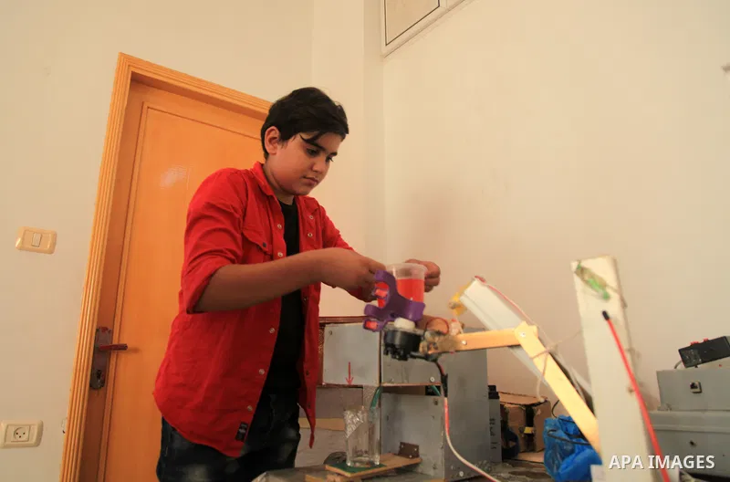 Palestinian inventor Mohammad Al-Hallaq,13, displays his small inventions at his home in Khan Yunis, in the southern Gaza Strip, on October 23, 2021. Al-Hallaq invented the robot for special needs and portable refrigerat...