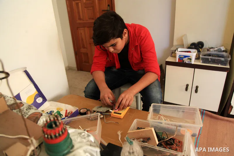 Palestinian inventor Mohammad Al-Hallaq,13, displays his small inventions at his home in Khan Yunis, in the southern Gaza Strip, on October 23, 2021. Al-Hallaq invented the robot for special needs and portable refrigerat...