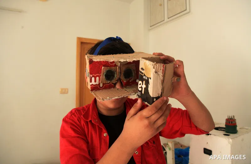 Palestinian inventor Mohammad Al-Hallaq,13, displays his small inventions at his home in Khan Yunis, in the southern Gaza Strip, on October 23, 2021. Al-Hallaq invented the robot for special needs and portable refrigerat...