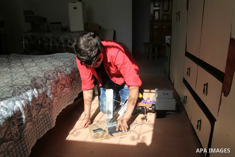 Palestinian inventor Mohammad Al-Hallaq,13, displays his small inventions at his home in Khan Yunis, in the southern Gaza Strip, on October 23, 2021. Al-Hallaq invented the robot for special needs and portable refrigerat...