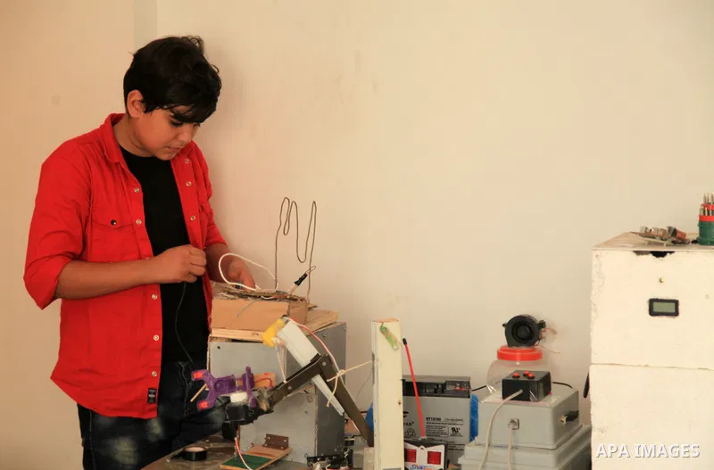 Palestinian inventor Mohammad Al-Hallaq,13, displays his small inventions at his home in Khan Yunis, in the southern Gaza Strip, on October 23, 2021. Al-Hallaq invented the robot for special needs and portable refrigerat...