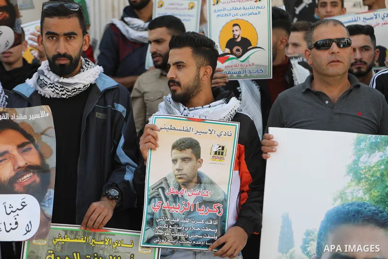 Palestinians take part in a protest in solidarity with prisoners on hunger strike at Israeli jails, in the West Bank city on October 24, 2021. Seven Palestinian prisoners in Israeli detention currently remain on hunger s...