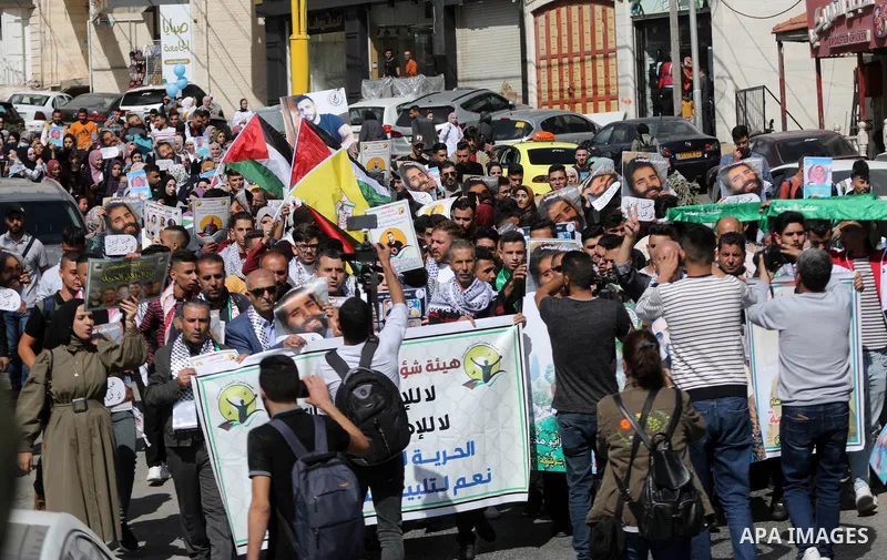 Palestinians take part in a protest in solidarity with prisoners on hunger strike at Israeli jails, in the West Bank city on October 24, 2021. Seven Palestinian prisoners in Israeli detention currently remain on hunger s...