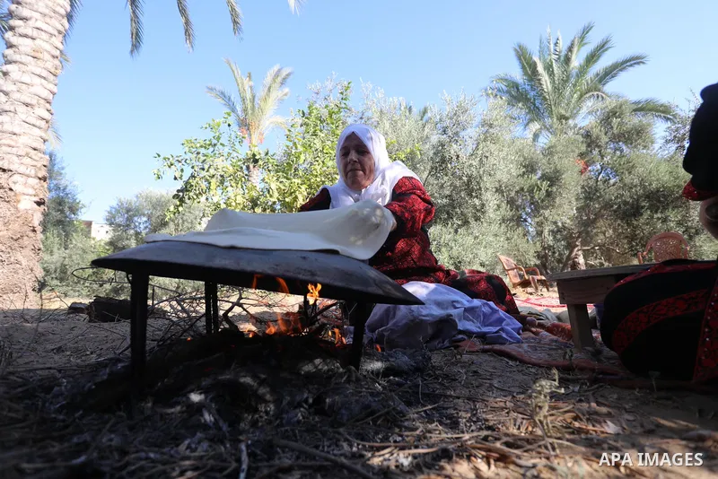 Palestinian women wear traditional dresses, as they pick olives during the harvest season, in Nuseirat camp in the central Gaza Strip, on 24 October 2021. Olive trees perform a crucial historical and cultural role in the...