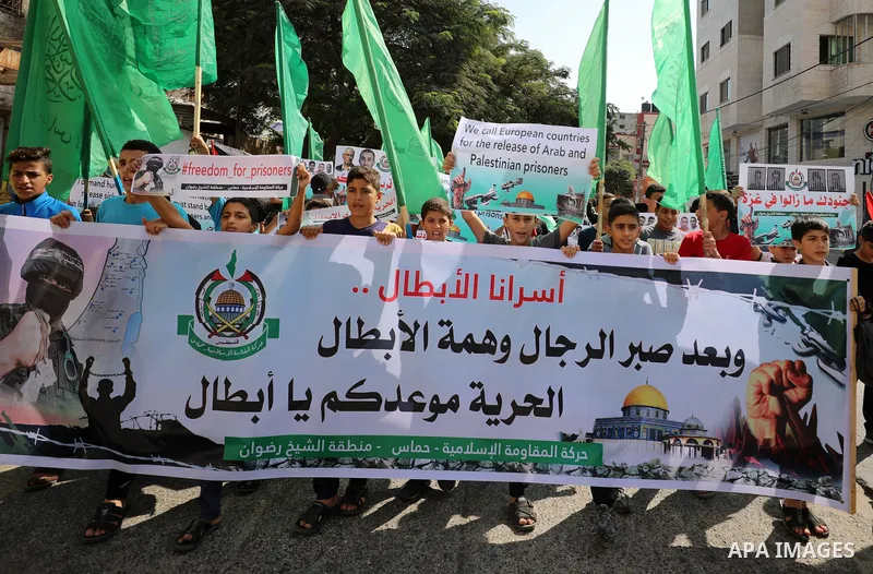 Palestinian children hold banners during a protest in solidarity with prisoners on hunger strike at Israeli jails, in front of Red Cross office in Gaza city on October 25, 2021. Photo by Mahmoud Nasser