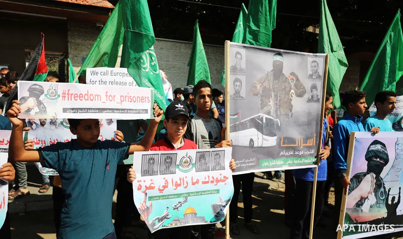 Palestinian children hold banners during a protest in solidarity with prisoners on hunger strike at Israeli jails, in front of Red Cross office in Gaza city on October 25, 2021. Photo by Mahmoud Nasser