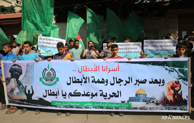 Palestinian children hold banners during a protest in solidarity with prisoners on hunger strike at Israeli jails, in front of Red Cross office in Gaza city on October 25, 2021. Photo by Mahmoud Nasser