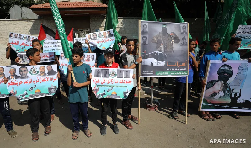 Palestinian children hold banners during a protest in solidarity with prisoners on hunger strike at Israeli jails, in front of Red Cross office in Gaza city on October 25, 2021. Photo by Mahmoud Nasser