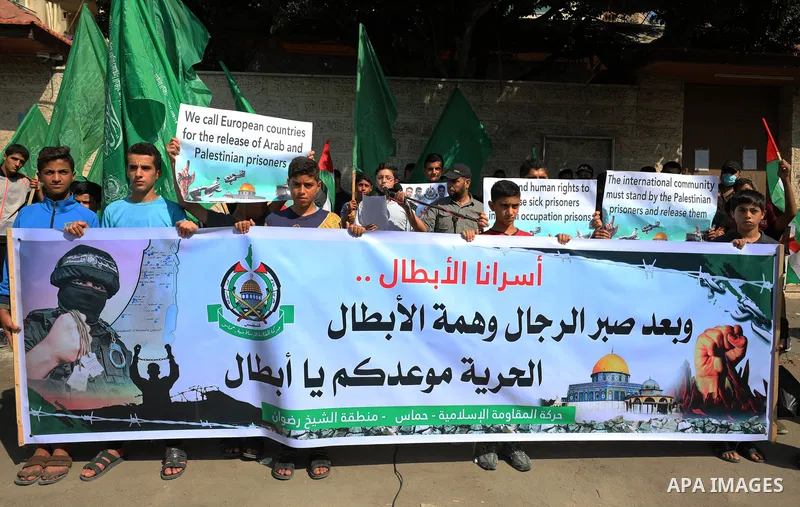 Palestinian children hold banners during a protest in solidarity with prisoners on hunger strike at Israeli jails, in front of Red Cross office in Gaza city on October 25, 2021. Photo by Mahmoud Nasser