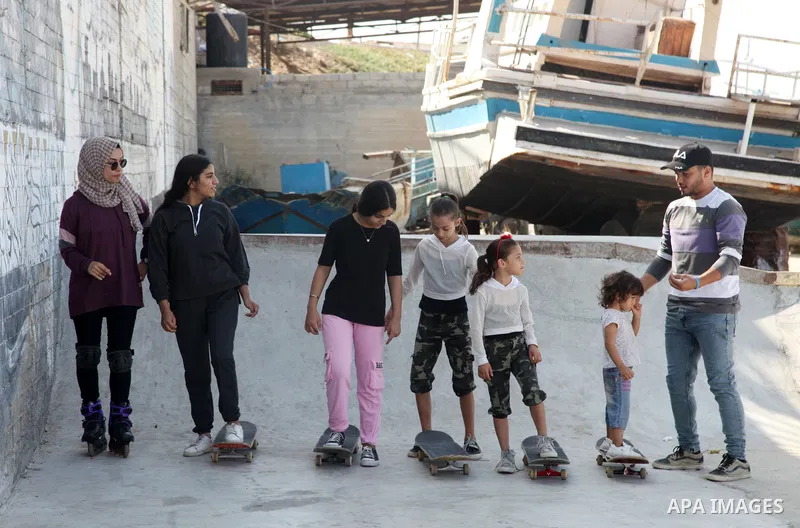 Palestinian girls practice on Skateboard sport at Gaza seaport, in Gaza city on October 27, 2021. A skateboard is a type of sports equipment used for skateboarding. They are usually made of a specially designed 7-8 ply m...