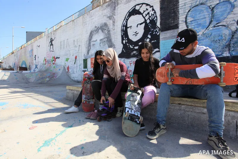 Palestinian girls practice on Skateboard sport at Gaza seaport, in Gaza city on October 27, 2021. A skateboard is a type of sports equipment used for skateboarding. They are usually made of a specially designed 7-8 ply m...