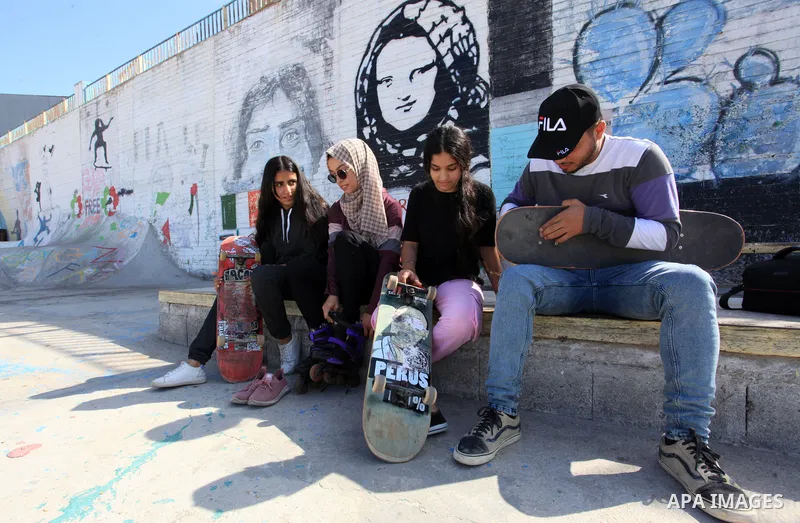 Palestinian girls practice on Skateboard sport at Gaza seaport, in Gaza city on October 27, 2021. A skateboard is a type of sports equipment used for skateboarding. They are usually made of a specially designed 7-8 ply m...