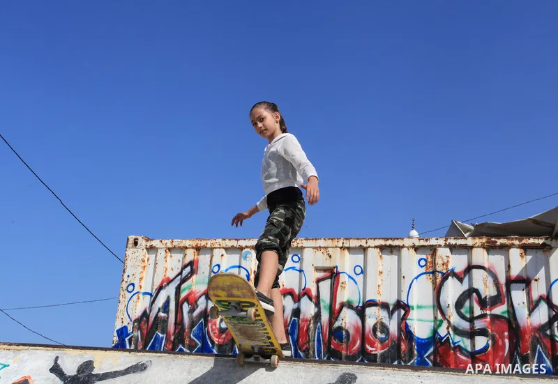 Palestinian girls practice on Skateboard sport at Gaza seaport, in Gaza city on October 27, 2021. A skateboard is a type of sports equipment used for skateboarding. They are usually made of a specially designed 7-8 ply m...