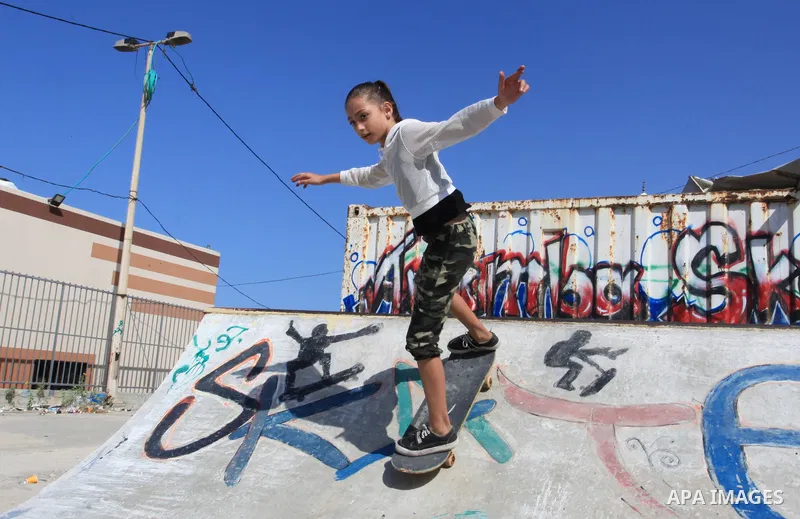Palestinian girls practice on Skateboard sport at Gaza seaport, in Gaza city on October 27, 2021. A skateboard is a type of sports equipment used for skateboarding. They are usually made of a specially designed 7-8 ply m...
